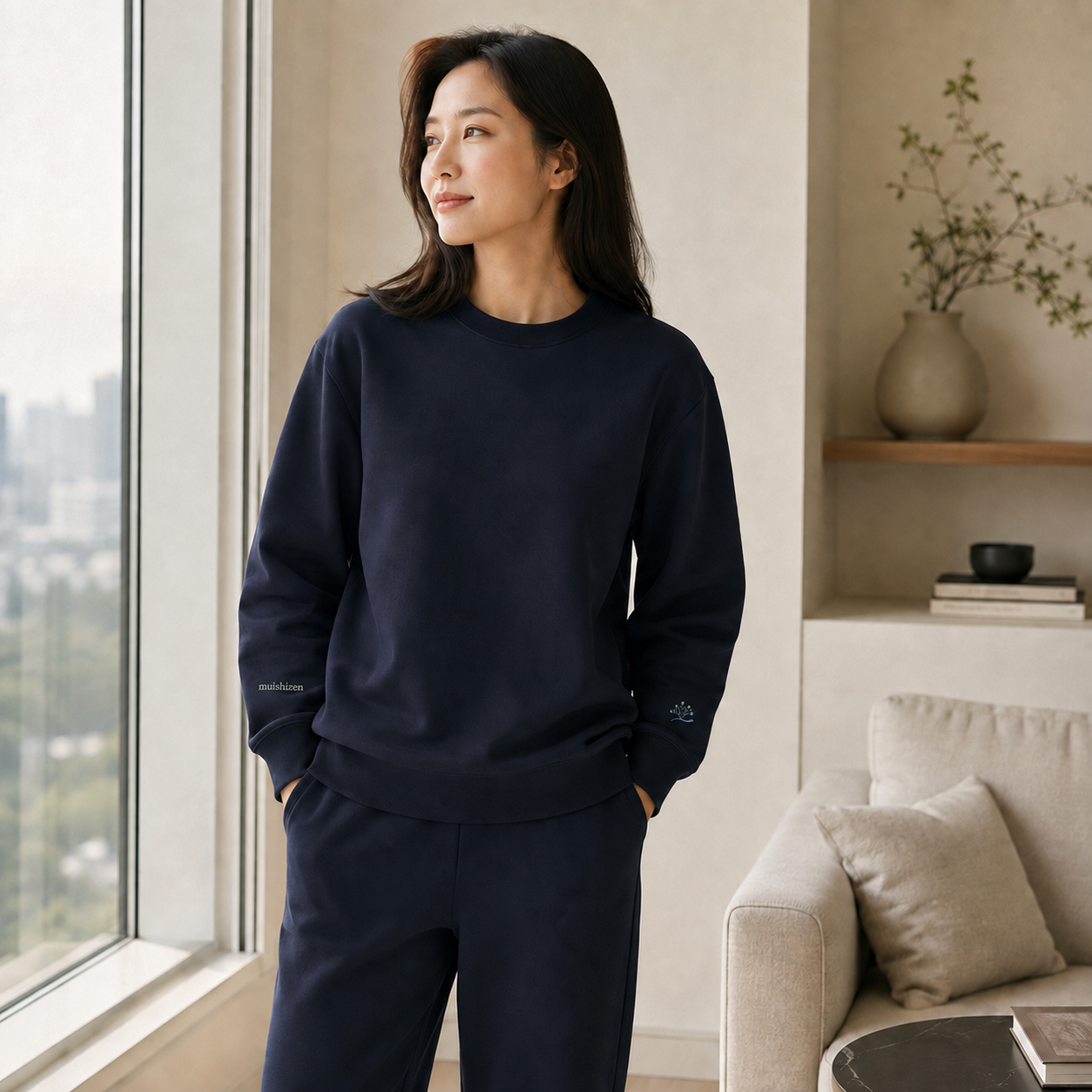 窓辺でネイビーの服を着てくつろぐ女性
